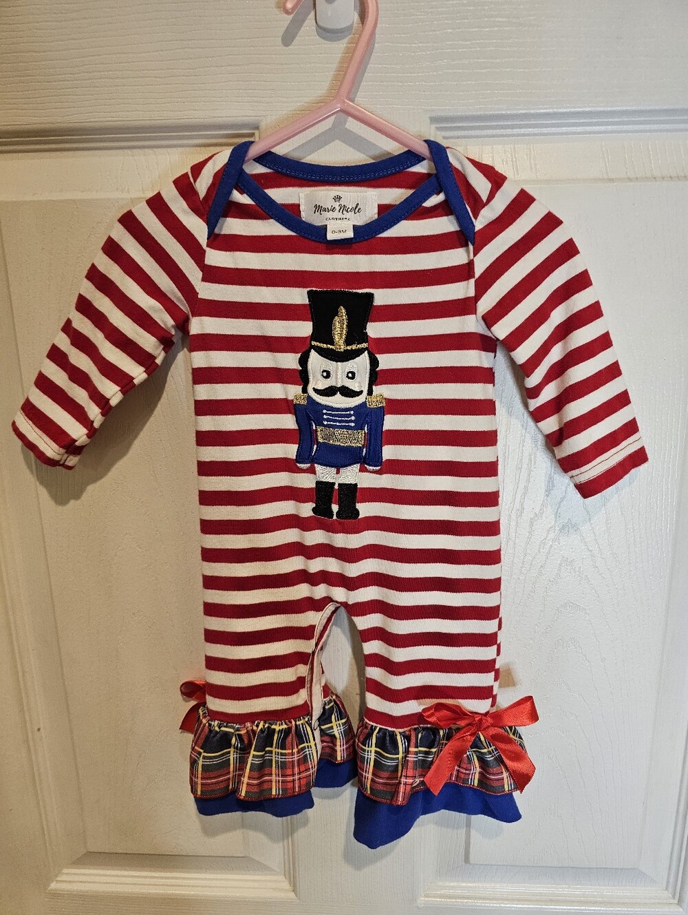 Baby Holiday One Piece With Nutcracker Detail And Plaid Ruffles With Red Bows .